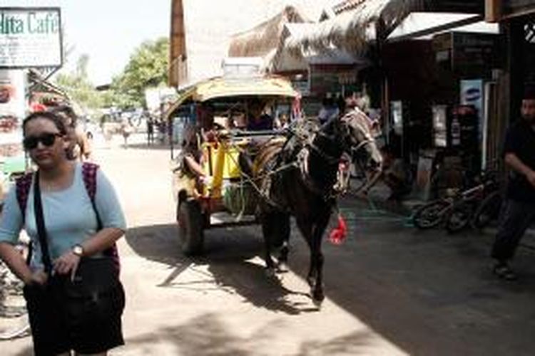 Wisatawan dan cidomo di Gili Trawangan, Lombok, Nusa Tenggara Barat, Minggu (17/2/2013).