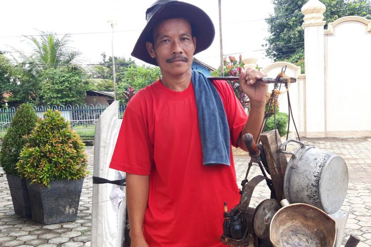 Soleh (45), tukang solder panci keliling dengan seperangkat peralatannya saat ditemui Kompas.com, Selasa (5/2/2019)