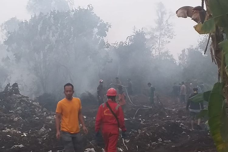Tim Satgas Karhutla dan sejumlah warga, berjibaku memadamkan api kebakaran lahan di Desa Rimbo Panjang, Kecamatan Tambang, Kabupaten Kampar, Riau, Minggu (22/9/2019).