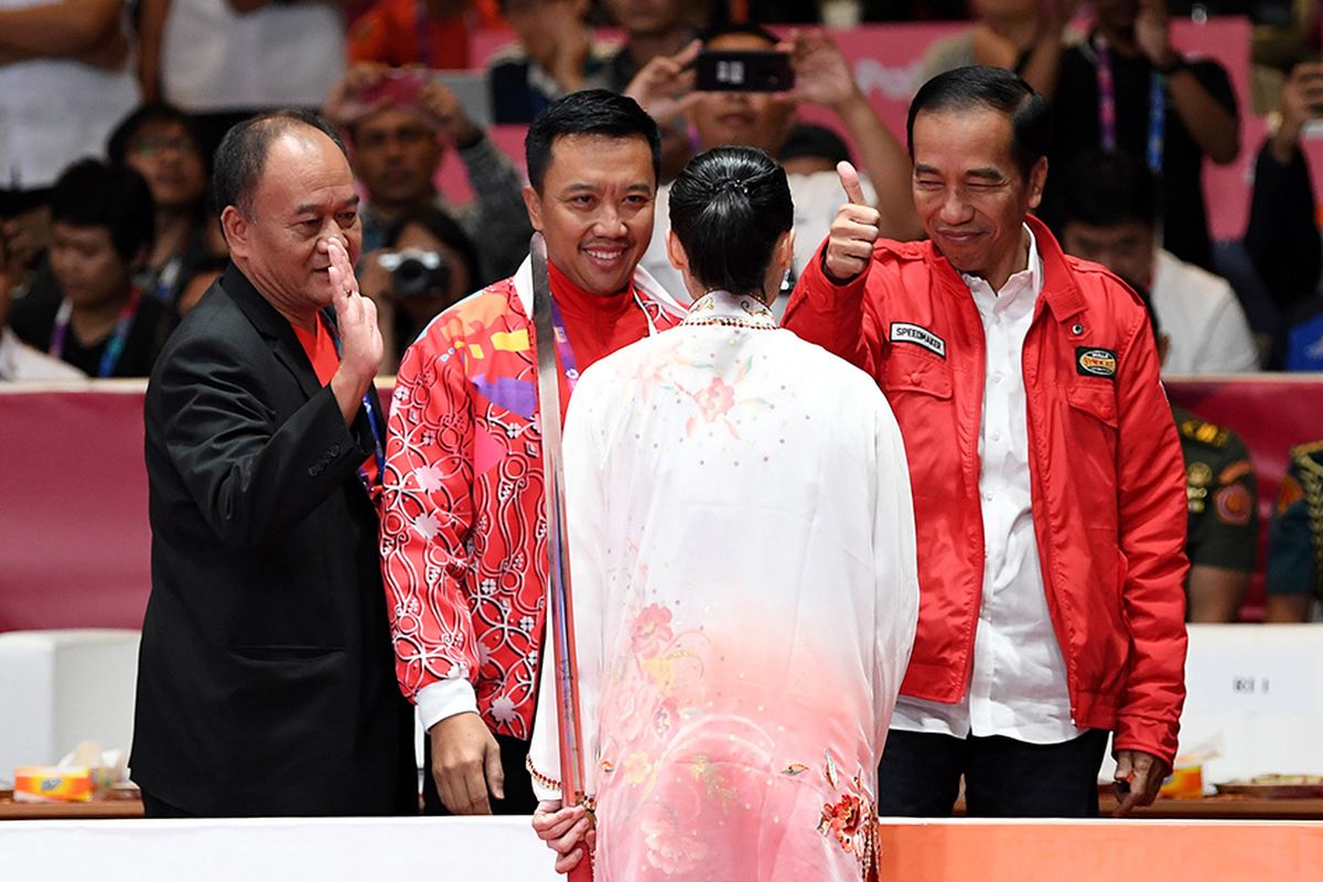 Presiden Joko Widodo (kanan) didampingi Menpora Imam Nahrawi (kedua kiri) memberi ucapan selamat kepada atlet Indonesia Lindswell usai bertanding dalam nomor Taijijian Putri Wushu Asian Games 2018 di JIExpo, Kemayoran, Jakarta, Senin (20/8/2018). Lindswell mempersembahkan emas kedua bagi kontingen Merah Putih usai berlaga dalam nomor Taijijian, meraih nilai tertinggi dengan total skor 9,75.