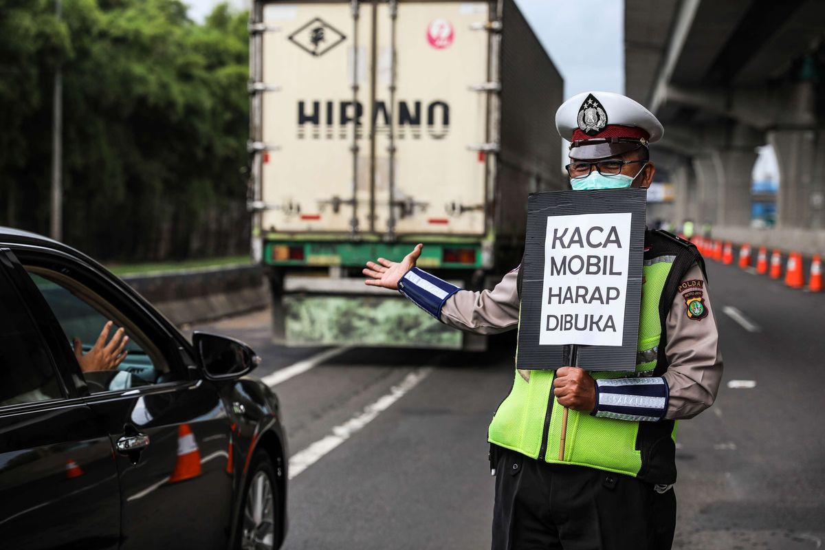 Polisi melakukan himbauan kepada penumpang yang melewati jalan tol Jakarta-Cikampek di Kabupaten Bekasi, Jawa Barat, Jumat (24/4/2020). Larangan mudik mulai diberlakukan 24 April 2020 pukul 00.00 WIB. Polda Metro Jaya melarang kendaraan pribadi baik motor atau mobil dan kendaraan umum berpenumpang keluar dari wilayah Jabodetabek. Pemeriksaan dan penyekatan kendaraan tersebut akan dilakukan di 18 titik pos pengamanan terpadu dan pos-pos check point di jalur tikus dan perbatasan.