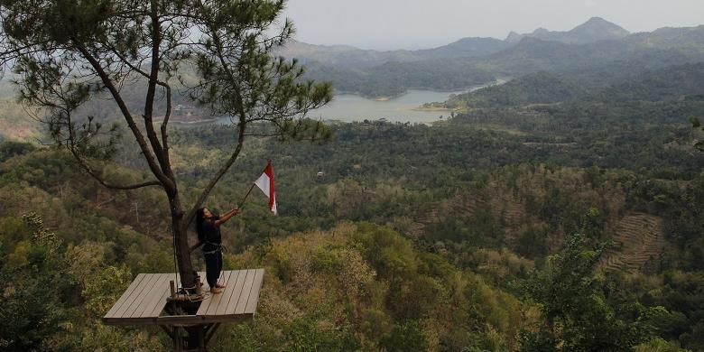 Salah satu wisatawan berfoto di spot foto 1 obyek wisata alam Kalibiru, Desa Hargowilis, Kecamatan Kokap, Kabupaten Kulon Progo, Yogyakarta, Sabtu (22/8/2015). Untuk dapat berfoto di spot foto 1 ini, wisatawan dikenakan tarif sebesar Rp15.000 dan diberi waktu berfoto selama tiga menit.