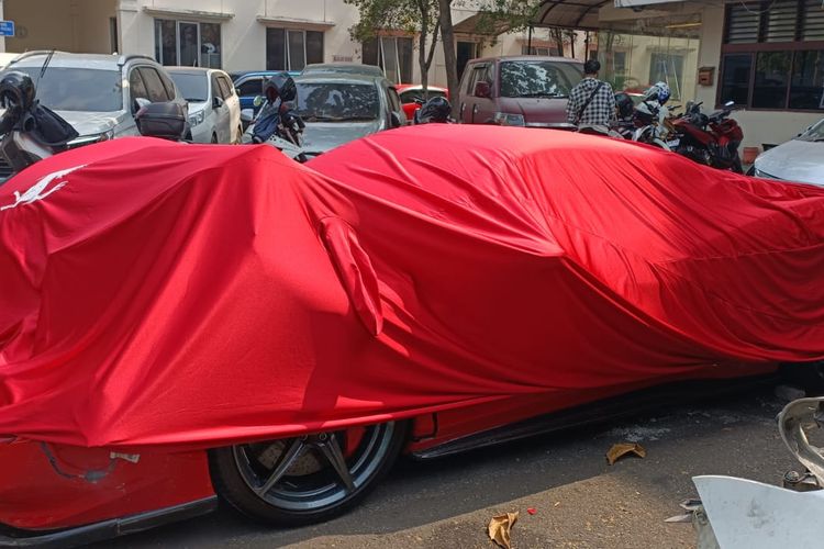 Mobil Ferrari merah milik RAS yang kini berada di kantor Subdit Gakkum Polda Metro Jaya, Senin (9/10/2023). Mobil itu diketahui menabrak sejumlah pengendara di Jalan Sudirman, dekat Bundaran Senayan, Jakarta Selatan, Minggu (8/10/2023) pagi.