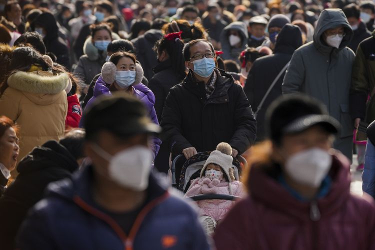 Para pengunjung memakai masker saat mengunjungi pusat perbelanjaan di Qianmen ketika hari pertama Tahun Baru Imlek di Beijing, China, Minggu (22/1/2023). Perkumpulan besar warga terjadi setelah pemerintah mencabut kebijakan nol Covid China yang ketat.