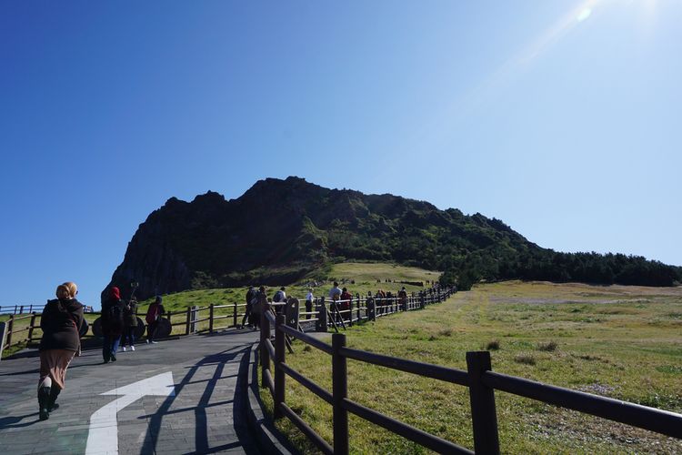 Turis di Seongsan llchulbong Tuff Cone di Pulau Jeju, Korea (Warisan Dunia UNESCO).