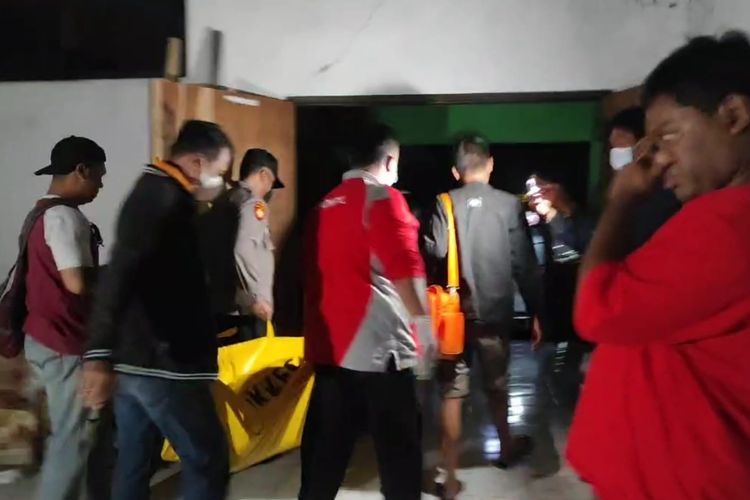 EVAKUASI—Petugas Polres Madiun Kota mengevakuasi jasad Slamet, seorang tukang becak yang ditemukan tewas di sebuah gedung kosong di belakang Kantor KPU Kota Madiun, Jawa Timur, Selasa (12/7/2022) malam. 
