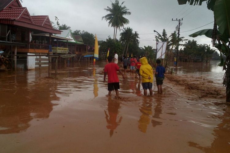 Sejumlah warga di Kabupaten Wajo, Sulawesi Selatan berupaya melewati banjir lumpur kiriman yang merendam dua desa setempat. Selasa, (8/8/2017).