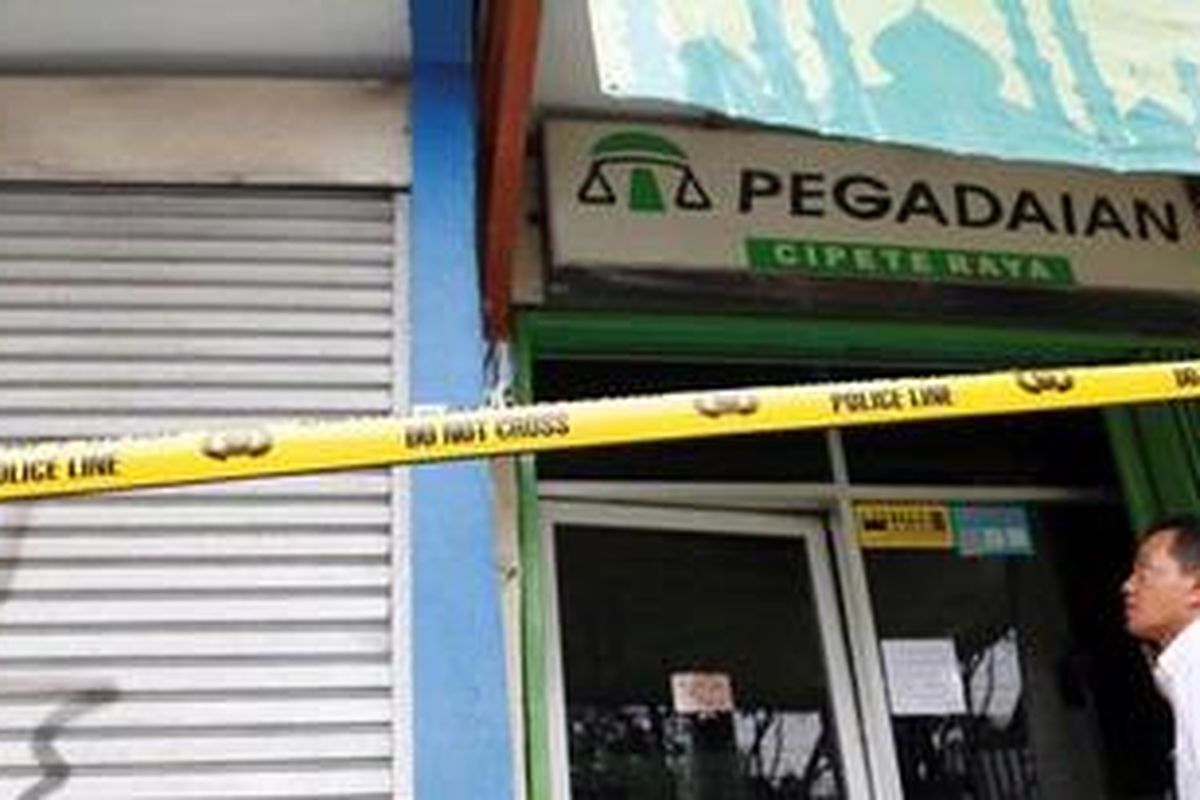 Polisi memasang garis polisi di depan pegadaian yang dirampok, di jalan Cipete Raya, Jakarta, Senin (5/11/2012). Pegadaian tersebut dirampok siang hari sekitar pukul 12.00 wib dalam kondisi jalanan di depannya ramai. 
