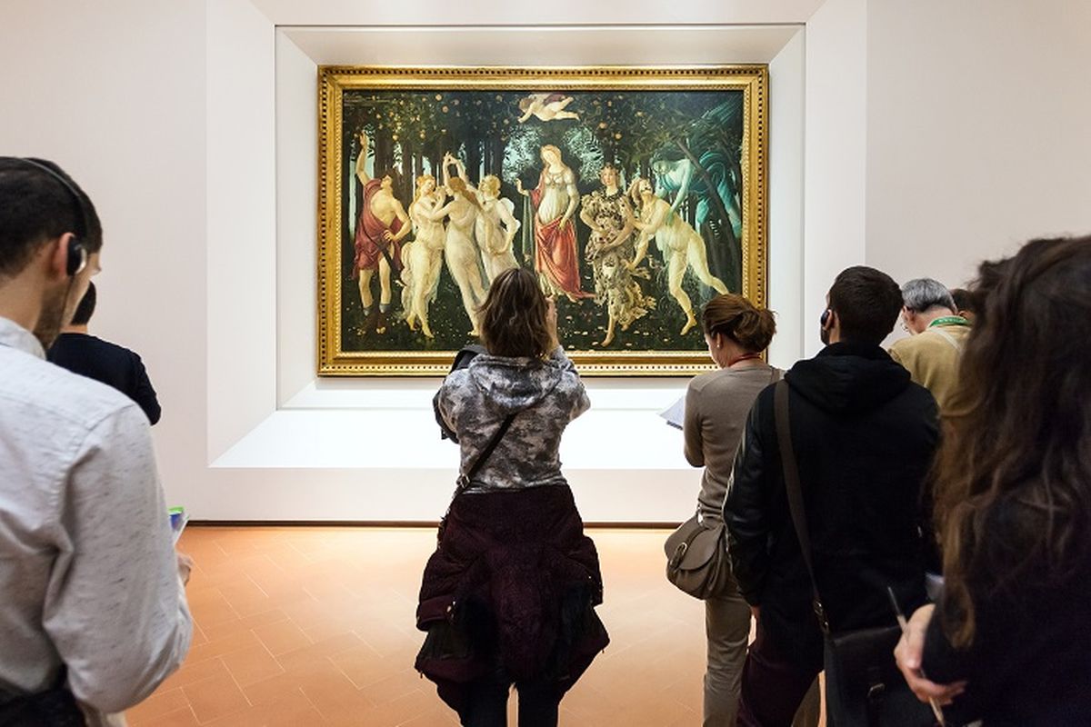 Ilustrasi museum - Seorang wisatawan tengah melihat lukisan di Ruang Botticelli di Uffizi Gallery, Italia.