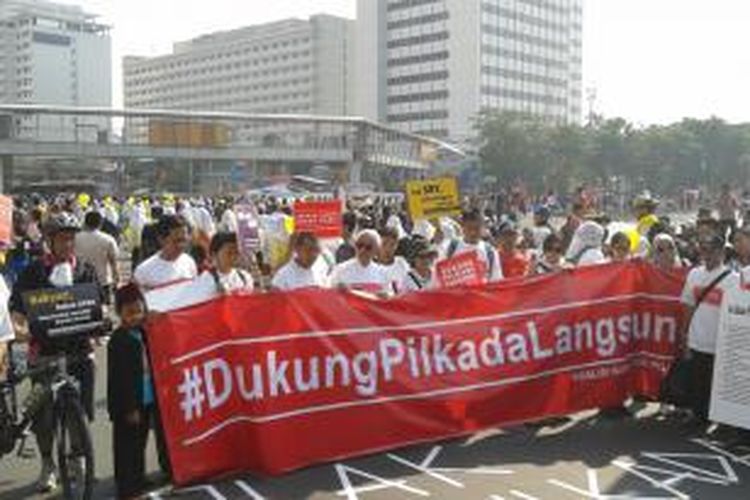 Sejumlah perwakilan dari lembaga swadaya masyarakat yang tergabung dalam Koalisi Kawal RUU Pikkada, membentangkan spanduk bertuliskan 