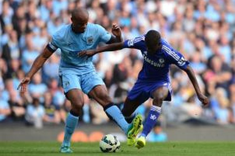 Kapten Manchester City Vincent Kompany (kiri) berebut bola dengan gelandang Chelsea Ramires, pada laga Premier League, di Etihad Stadium, Minggu (21/9/2014). Laga itu berahir 1-1.