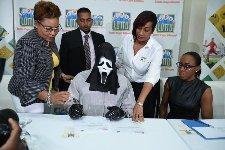 A Campbell, pemenang lotre Rp 15,6 miliar di Jamaika, memakai topeng saat mengambil hadiahnya pada 5 Februari 2019 di Spanish Court Hotel, Kingston.
