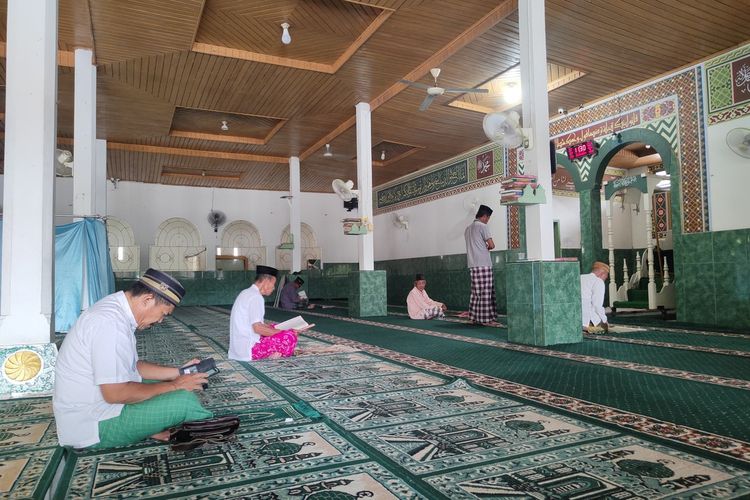 Sejumlah warga membaca Alquran di dalam masjid Almuttaqin Desa Yosonegoro. Tiang-tiang yang menyangga struktur bangunan masjid ini adalah tiang kayu besi yang masih asli sejak pembangunan awal masjid ini.