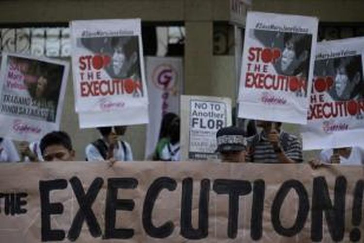 Pengunjuk rasa membawa poster menyerukan pemerintah Indonesia untuk menunda eksekusi terhadap terpidana mati asal Filipina yaitu Mary Jane Veloso, dalam aksi di luar Kedutaan Besar Indonesia di Makati, Manila, Filipina, 26 April 2015.