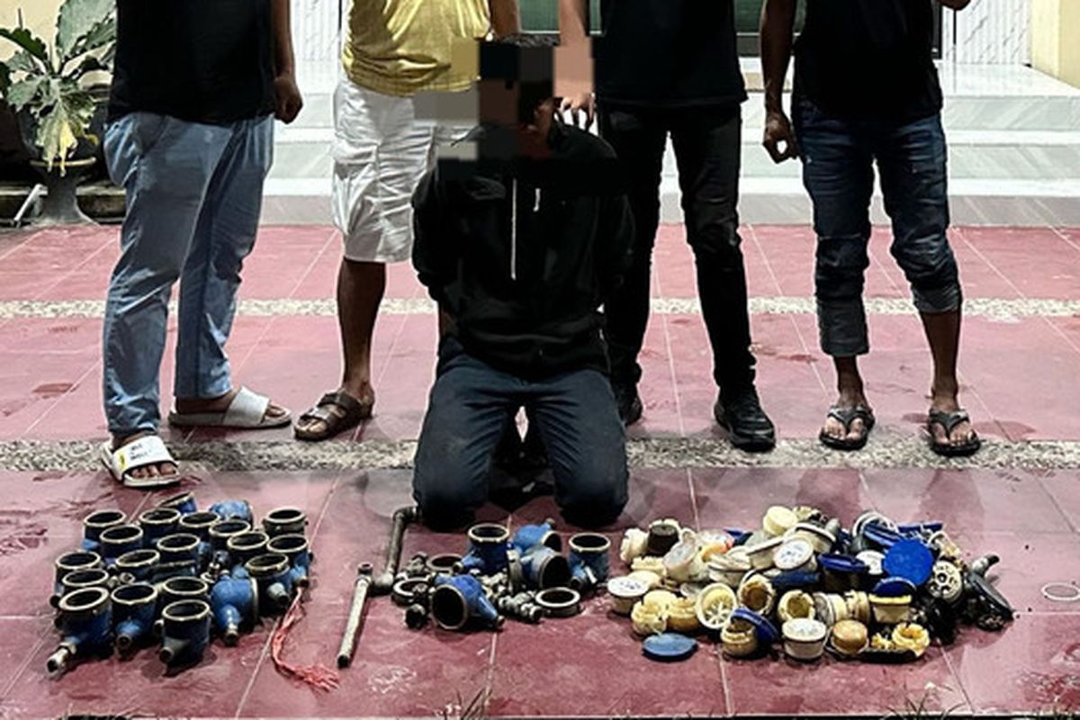 FGN (jongkok) tersangka pencurian dan barang bukti meter air saat digelandang di Mapolresta Gorontalo Kota. FGN nekat mencuri karena terlilit hutang.