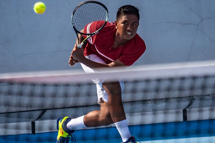 Petenis Indonesia Gunawan Trimuswantara berupaya mengembalikan bola ke arah petenis Thailand Prachaya Baibong pada pertandingan Round Robin Tenis Beregu Putra ASEAN Schools Games ke-11 Tahun 2019 di GOR Tri Lomba Juang, Semarang, Jawa Tengah, Minggu (21/7/2019). Tim tenis  putra Indonesia berhasil menyabet medali emas setelah mengalahkan tim tenis putra Thailand dengan skor 3-2.