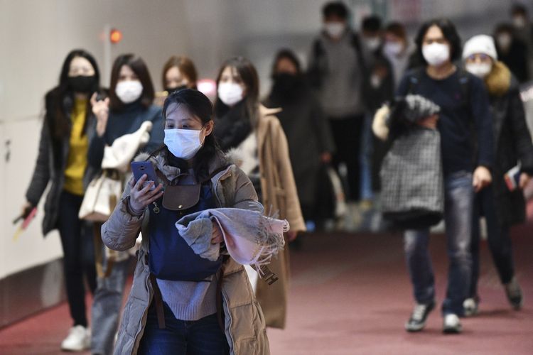 Penumpang dari luar negeri menggunakan masker untuk mencegah penyebaran virus Corona saat tiba di Bandara Internasional Haneda, 28 Januari 2020. 