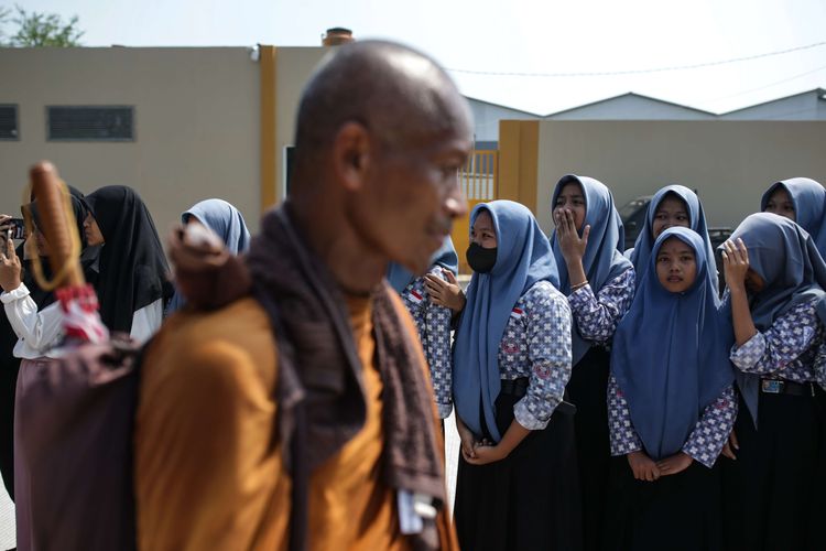 Antusias warga menyambut biksu yang melintas menjalani ritual thudong saat perjalanan dari Kota Tegal ke Pemalang, Jawa Tengah, Rabu (24/5/2023). Sebanyak 32 biksu jalan kaki dari Thailand menuju Candi Borobudur untuk meyambut Hari Raya Waisak.