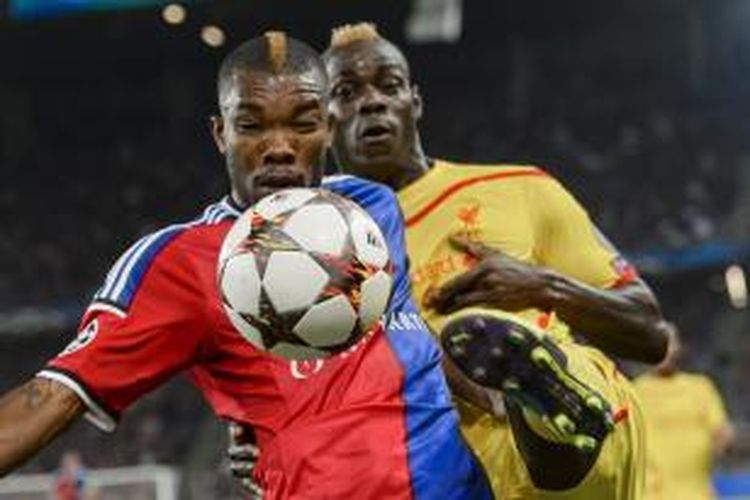 Gelandang FC Basel, Geoffroy Serey Die (kiri), berebut bola dengan penyerang Liverpool, Mario Balotelli, pada matchday kedua Grup B Liga Champions, di St Jakob Park, Basel, Rabu (1/10/2014).