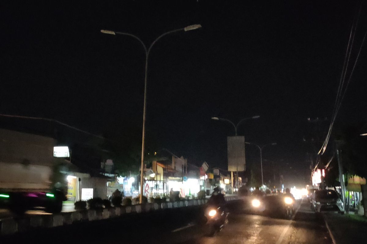 Pengendara sepeda motor melintasi Jalan Cipto Mangunkusumo Kota Tegal, Jawa Tengah, dimana lampu PJU dipadamkan jelang pemberlakuan PPKM Level 3 serentak, Senin (6/12/2021)