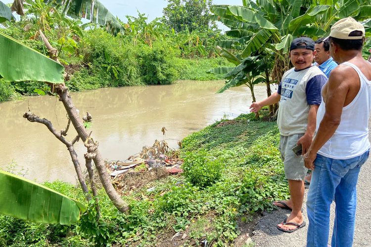 Irfan (topi biru tua) melihat buaya di Sungai Bligo, Sidoarjo pada Senin (30/11/2024) dini hari.