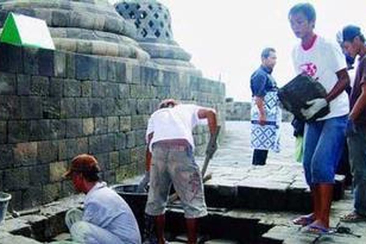 Pekerja di Balai Konservasi Peninggalan Borobudur membersihkan drainase lantai Candi Borobudur di Magelang, Jawa Tengah, Jumat (25/3/2011). Pascaerupsi Gunung Merapi, saluran air dan celah dinding batu Borobudur masih penuh dengan abu vulkanik Merapi.