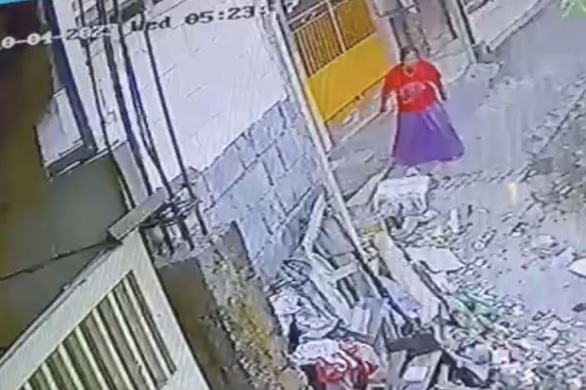 Masriah saat membuang sampah ke rumah tetangganya