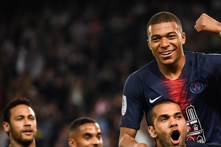 Bek Paris Saint-Germain Dani Alves (bawah) dan Kylian Mbappe (mengepalkan tangan) berselebrasi setelah mencetak gol dalam pertandingan Ligue 1 antara Paris Saint-Germain (PSG) dan Monaco pada 21 April 2019 di Stadion Parc des Princes di Paris.