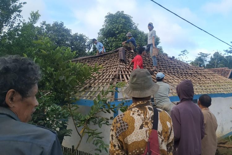 Masyarakat bergotongroyong menurunkan genting rumah Irah di Dusun Ciherang, Desa Cijangkar, Kecamatan Nyalindung, Sukabumi, Jawa Barat, Jumat (12/2/2021). KOMPAS.COM/BUDIYANTO