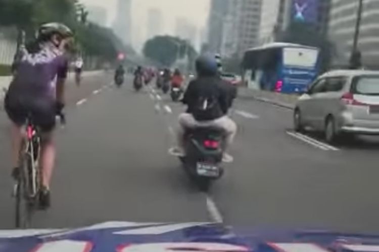 Polisi menegur rombongan pesepeda yang melintas di luar jalur sepeda di jalan Sudirman, Jakarta, Selasa (6/12/2022).
