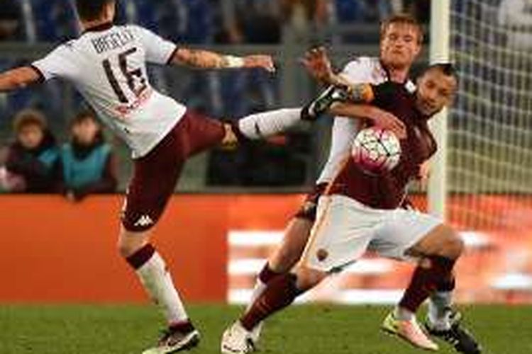 Gelandang AS Roma, Radja Nainggolan (kanan), mendapatkan pengawalan ketat dari dua pemain Torino, dalam lanjutan Serie A di Stadion Olimpico, Roma, Rabu (20/4/2016) waktu setempat.