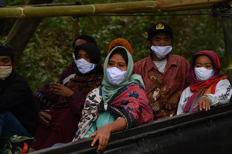 Masyarakat Suku Tengger dengan mengenakan masker berada di mobil bak terbuka menuju kawasan Gunung Bromo untuk melaksanakan perayaan Yadnya Kasada, Probolinggo, Jawa Timur, Senin (6/7/2020). Perayaan Yadnya Kasada merupakan bentuk ungkapan syukur masyarakat Suku Tengger dengan melarung sesaji berupa hasil bumi dan ternak ke kawah Gunung Bromo.