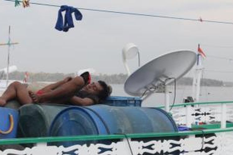 Nelayan tidur di atas drum pada kapal yang bersandar di dermaga TPI Cempae, Parepare, Sulawesi Selatan, Sabtu (15/11/2014). Sudah tiga hari terakhir ini ratusan nelayan di Kota Parepare tidak melaut akibat kehabisan solar.