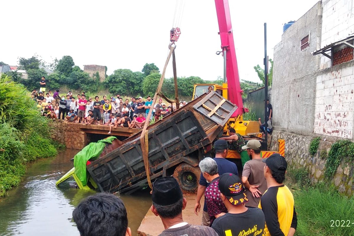 Evakuasi truk bermuatan batu yang terperosok ke kali di Jalan Telaga, Kedaung, Sawangan, Depok, Senin (21/2/2022). 