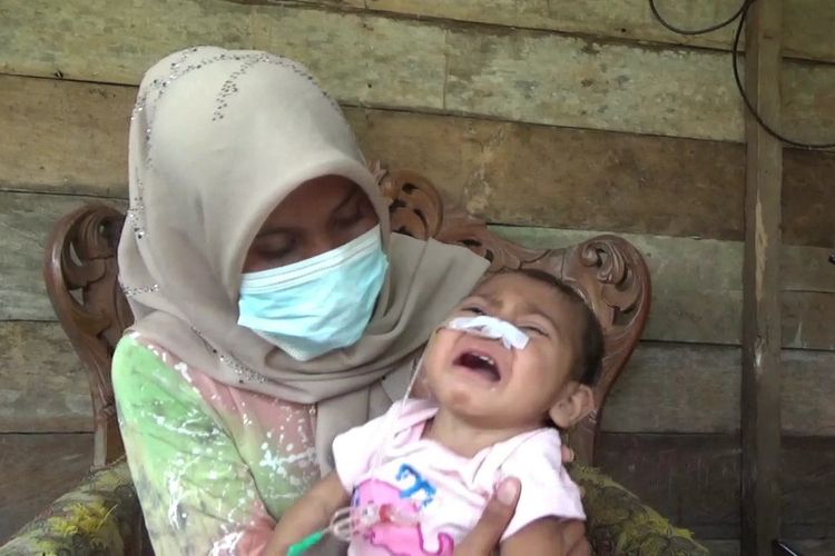Aqila Fitriana, 20 bulan berada di gendongan ibunya di Desa Meunasah Ampeh, Kecamatan Tanah Luas, Kabupaten Aceh Utara, Sabtu (6/2/2021).