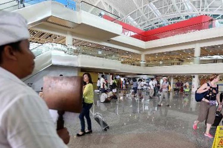 Seorang pemandu wisata menjemput wisatawan di terminal kedatangan internasional Bandara Ngurah Rai, Bali, Rabu (12/3/2014). Kunjungan wisatawan ke Bali masih terpantau ramai menjelang Hari Raya Nyepi.