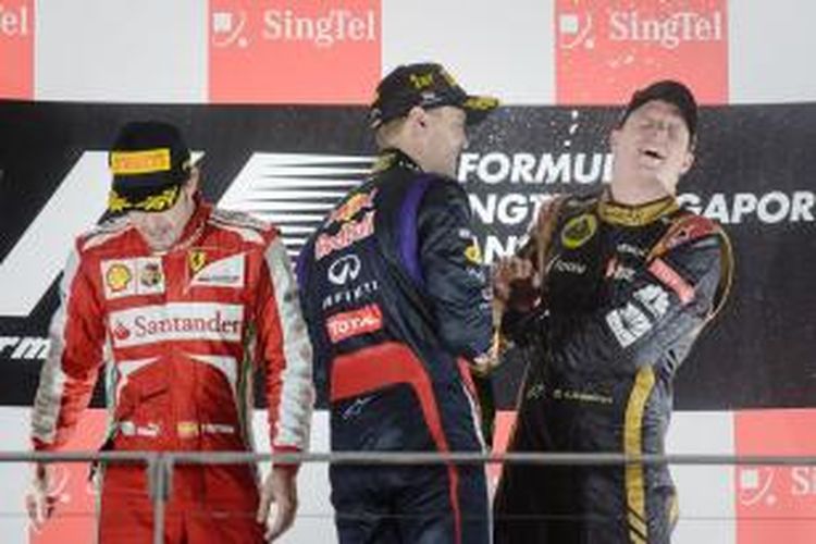 Pebalap Red Bull Racing asal Jerman, Sebastian Vettel (tengah) merayakan kemenangan pada GP Singapura di podium Sirkuit Marina Bay Street, bersama pebalap Lotus dari Finlandia, Kimi Raikkonen (kanan) yang finis ketiga, dan pebalap Ferrari asal Spanyol, Fernando Alonso yang finis kedua, Minggu (22/9/2013).