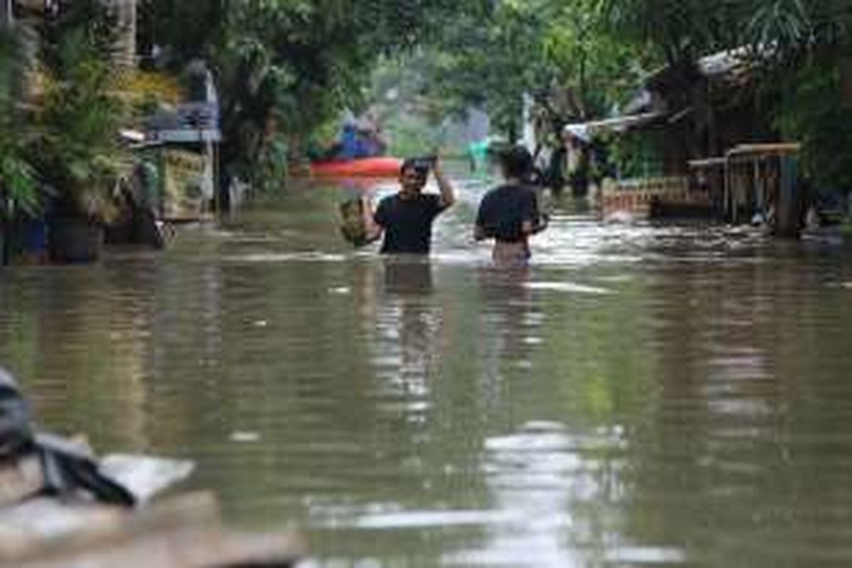 Sorang warga terlihat sedang menyelamatkan barang-barang yang terkena banjir di Perumahan Total Persada Kota Tangerang, Senin (14/11/2016). Banjir di Kota Tangerang disebabkan oleh luapan dari beberapa kali dan tersumbatnya drainase di sejumlah titik.
