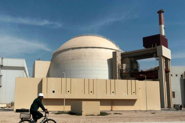 Seorang pekerja mengendarai sepeda melintas di depan reaktor pembangkit listrik tenaga nuklir Bushehr di Kota Busher, Iran, 26 Oktober 2010.