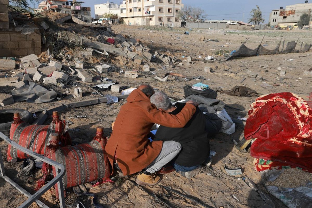Seorang pria Palestina menghibur seorang pria Palestina lainnya ketika mereka memeriksa kehancuran di Rafah pada Minggu (18/2/2024), setelah serangan udara Israel semalam di kota perbatasan Jalur Gaza selatan di tengah pertempuran yang sedang berlangsung antara Israel dan gerakan Hamas Palestina. Prospek gencatan senjata Israel-Hamas meredup pada 18 Februari setelah Amerika Serikat mengisyaratkan akan memveto dorongan terbaru untuk resolusi Dewan Keamanan PBB dan mediator Qatar mengakui bahwa pembicaraan gencatan senjata di bidang diplomatik lainnya telah menemui jalan buntu. 