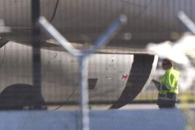 Petugas memeriksa mesin pesawat Airbus A330 milik maskapai China Eastern Airlines yang berlubang beberapa saat setelah lepas landas dari bandara Sydney, Australia.