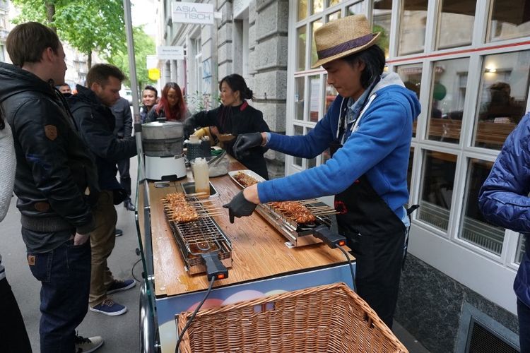 Warga kota Zurich, Swiss nampak antusias melihat proses pembakaran sate yang dilakukan Rio di atas sebuah gerobak.