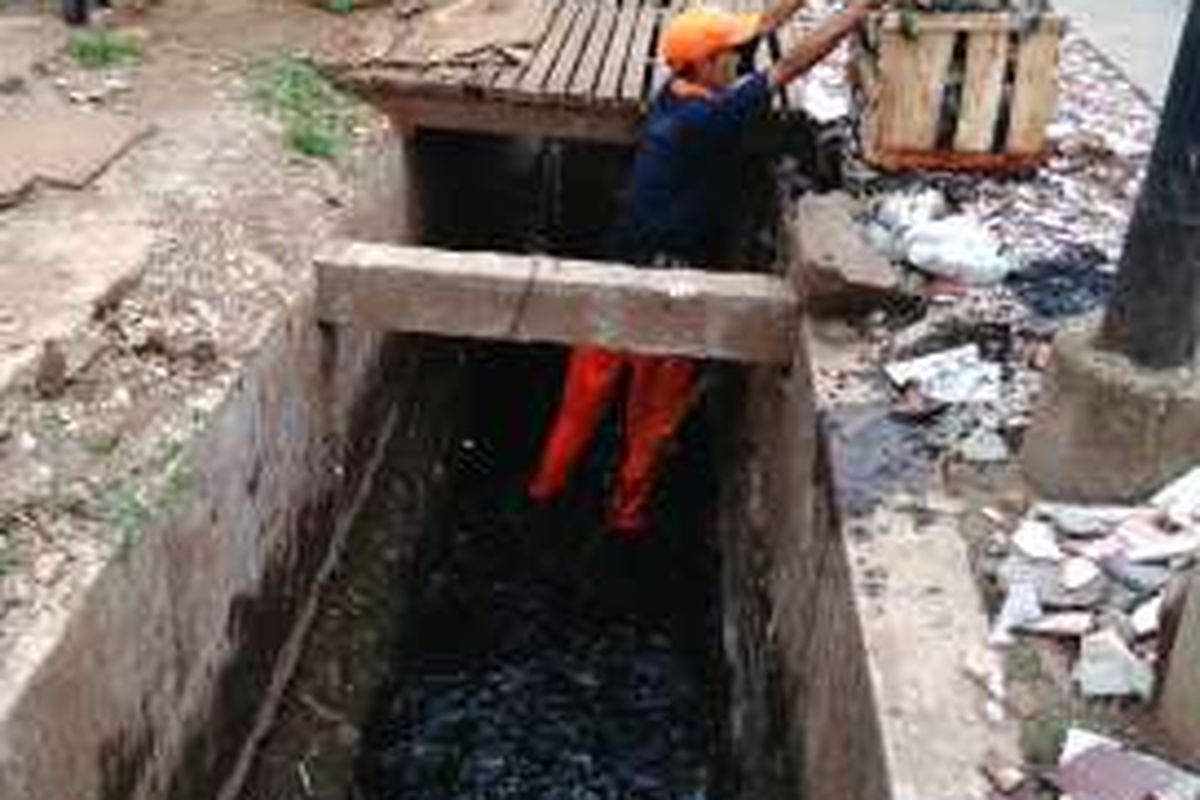 Seorang petugas prasarana dan sarana umum (PPSU) nampak sedang bekerja membersihkan sampah di saluran air depan Pasar Warung Buncit, kawasan Kelurahan Bangka, Kecamatan Pancoran, Jakarta Selatan. Senin (16/5/2016).  