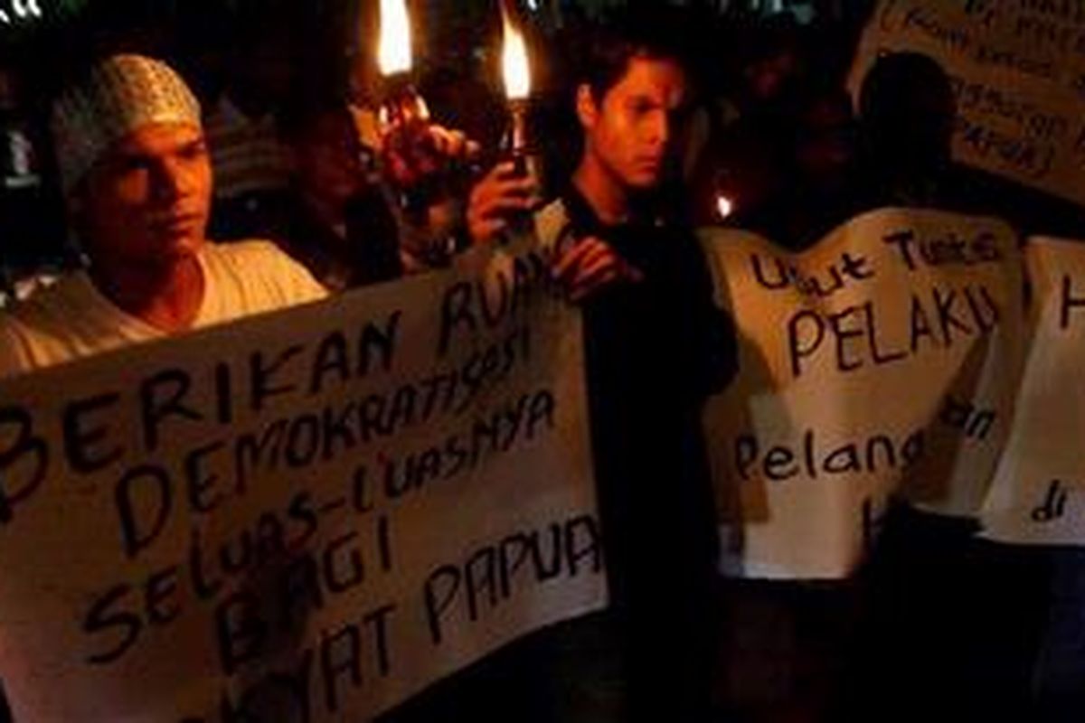 Sejumlah pengunjuk rasa membawa poster saat menggelar aksi unjuk rasa di Bunderan UGM, Yogyakarta, Senin (14/11/2011) malam. Dalam aksi yang diikuti oleh puluhan anggota dari Solidaritas Anak Bangsa Untuk Kemanusiaan (SABUK) tersebut menuntut penghentian pelanggaran HAM di Papua.