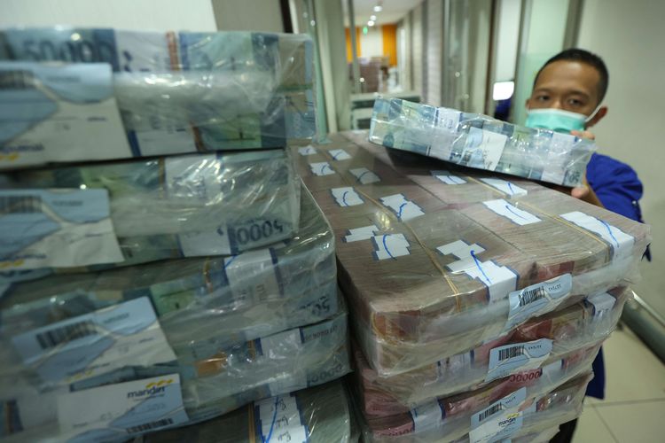 Petugas merapikan uang rupiah untuk didistribusikan di cash center Bank Mandiri di Mandiri Plaza, Jakarta, Rabu (3/8/2022).