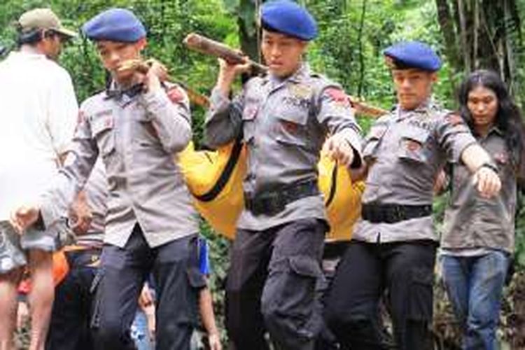 Personel Brimob yang tergabung dalam tim SAR gabungan saat mengevakuasi satu jenazah dari lokasi banjir bandang Sibolangit, Senin (16/5/2016)