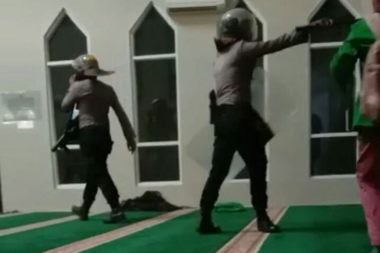 Anggota Polisi masuk masjid mengenakan sepatu sambil membawa tameng dan pentungan memukuli mahasiswa terekam video amatir dan menjadi viral di media sosial.