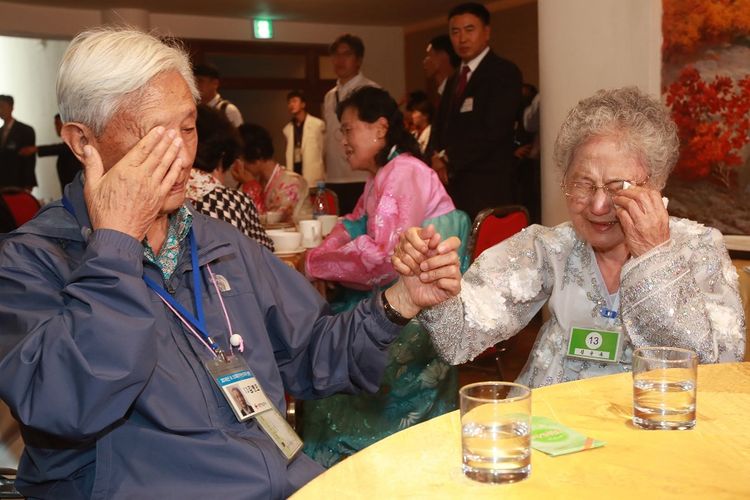 Kim Byung-oh yang berasal dari Korea Selatan (kiri) menangis sambil menggenggam tangan adiknya, Kim Sun Ok yang tinggal di Korea Utara. Kakak beradik berusia 88 dan 81 tahun itu terpisah akibat Perang Korea 1950-1953. Mereka kembali setelah 68 tahun lamanya melalui reuni yang digelar sejak Senin (20/8/2018) hingga Rabu (22/8/2018).