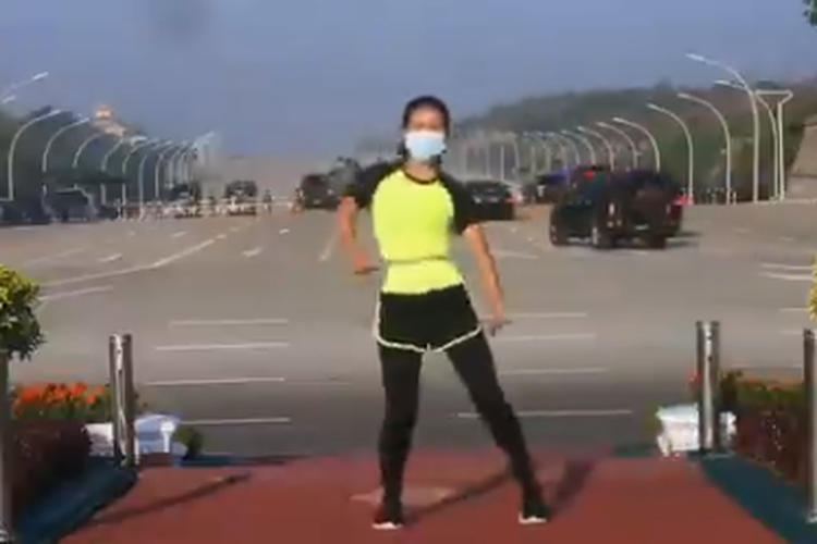 Tangkapan layar video perempuan sedang melakukan senam aerobik dengan latar belakang terjadinya kudeta di gedung parlemen di Myanmar.