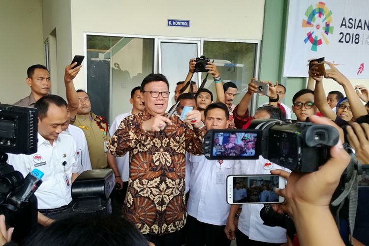 Menteri Dalam Negeri Tjahjo Kumolo memotong ujung kanan atas salah satu e-KTP yang rusak di gudang penyimpanan barang inventarisasi Kemendagri, Bogor, Jawa Barat, Rabu (30/5/2018)